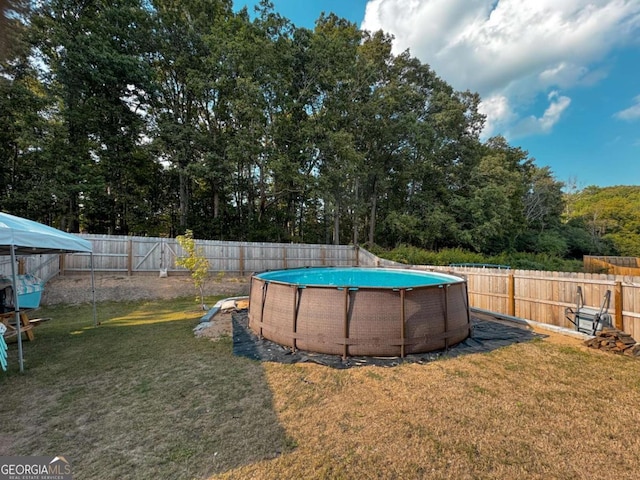 view of pool with a lawn