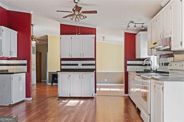 kitchen with vaulted ceiling, white cabinetry, white range with electric cooktop, and tasteful backsplash