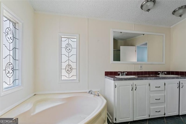 bathroom with a textured ceiling, vanity, a tub to relax in, and tile patterned floors