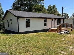 view of front of house with a deck and a front lawn