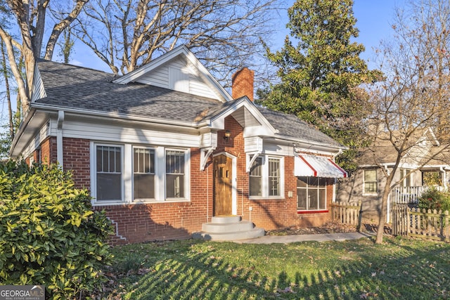 bungalow-style home with a front yard