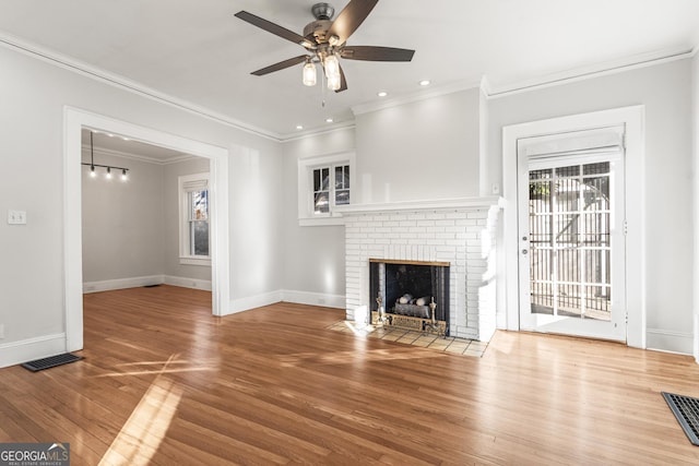 unfurnished living room with a fireplace, hardwood / wood-style flooring, ceiling fan, and ornamental molding