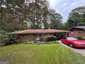 ranch-style home with a carport and a front lawn