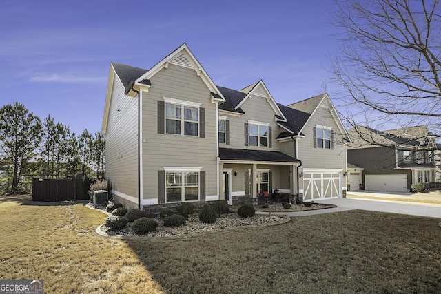 view of front of property with a garage, central AC unit, and a front yard