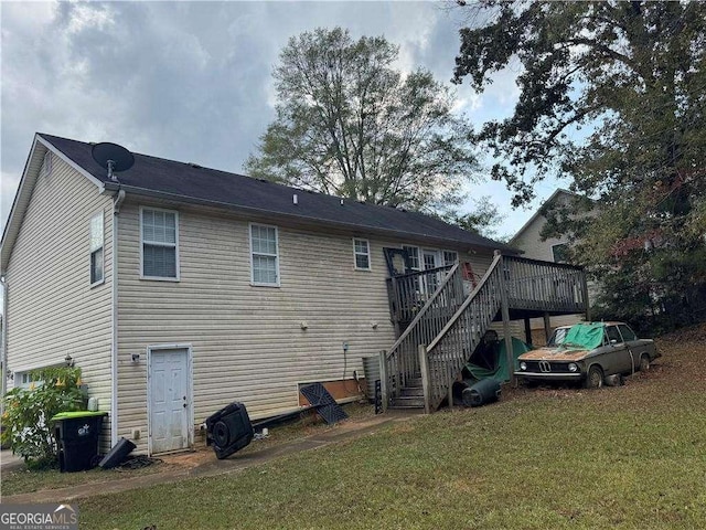 rear view of house with a lawn and a deck