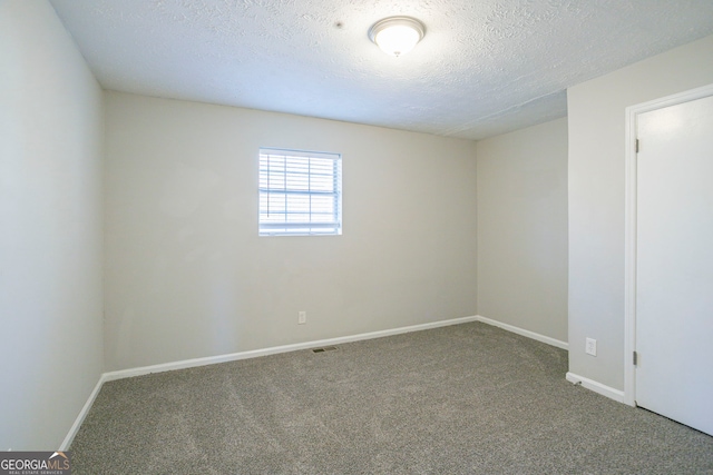 carpeted spare room with a textured ceiling