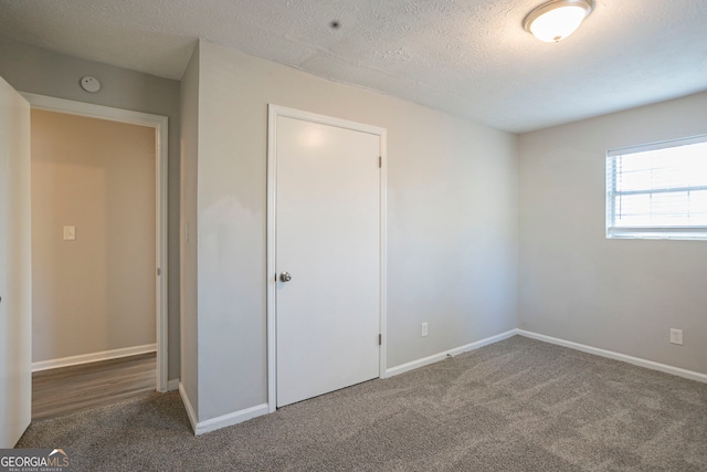 unfurnished bedroom featuring carpet and a textured ceiling