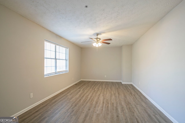 spare room with hardwood / wood-style floors, ceiling fan, and a textured ceiling