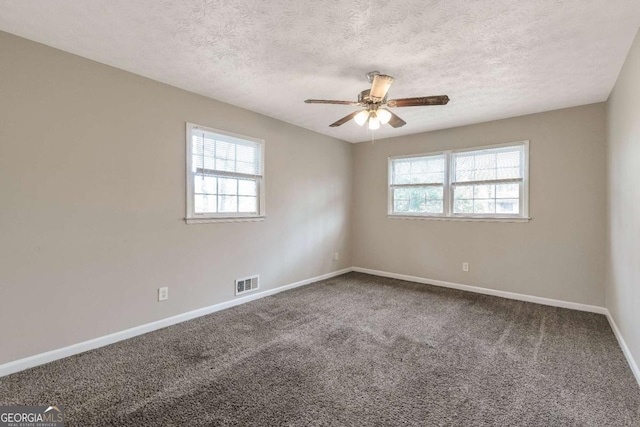 carpeted spare room featuring ceiling fan and a textured ceiling