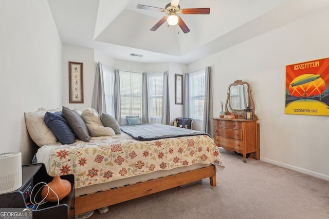 bedroom featuring ceiling fan, carpet, and a tray ceiling