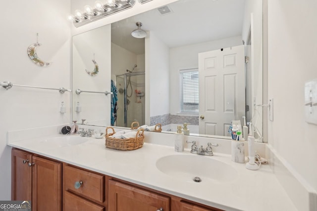 bathroom with a shower with shower door and vanity