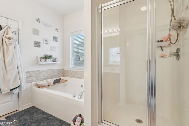 bathroom featuring shower with separate bathtub