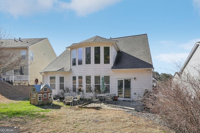 rear view of house featuring a lawn and a patio