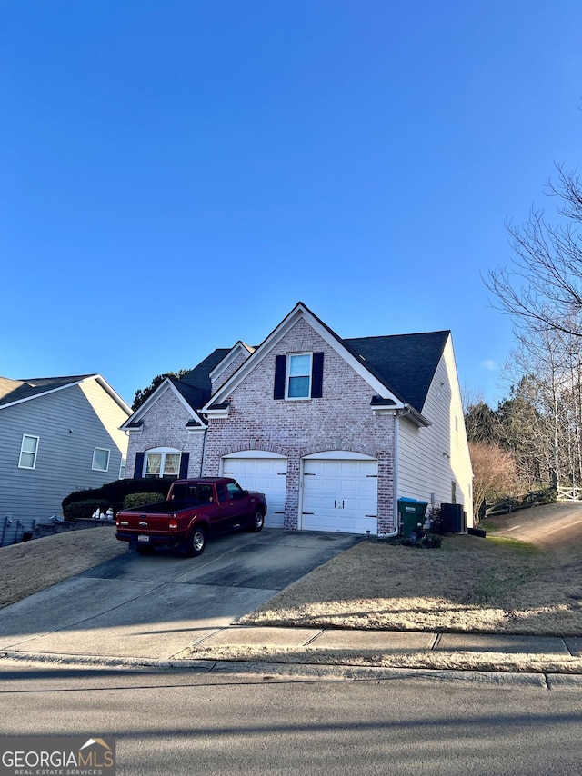 view of front property featuring a garage and central AC