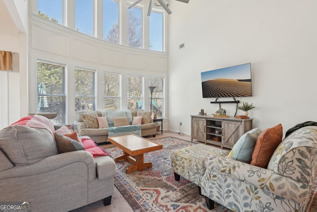 living room with ceiling fan and a high ceiling