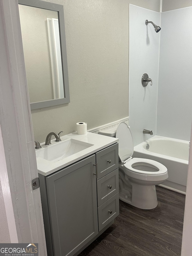 full bathroom with wood-type flooring, vanity, toilet, and shower / washtub combination