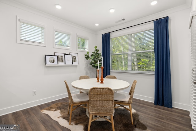 dining space with dark hardwood / wood-style flooring and ornamental molding