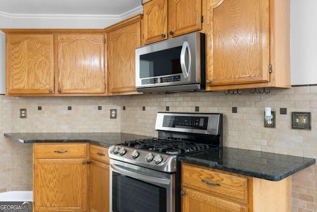 kitchen featuring stainless steel appliances, tasteful backsplash, and dark stone counters