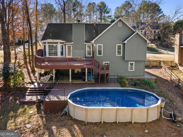 rear view of property featuring a pool side deck