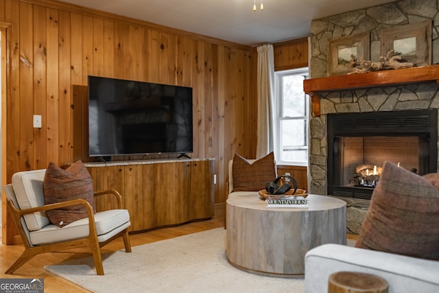 sitting room featuring wood walls, a fireplace, and light wood-type flooring