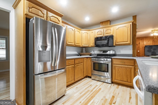 kitchen featuring ceiling fan, appliances with stainless steel finishes, and light hardwood / wood-style flooring