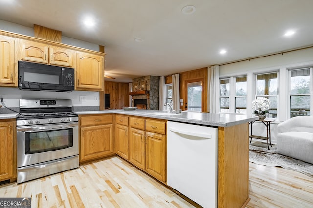 kitchen with dishwasher, kitchen peninsula, sink, and stainless steel range with gas stovetop