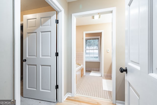 hall with light tile patterned floors and a textured ceiling