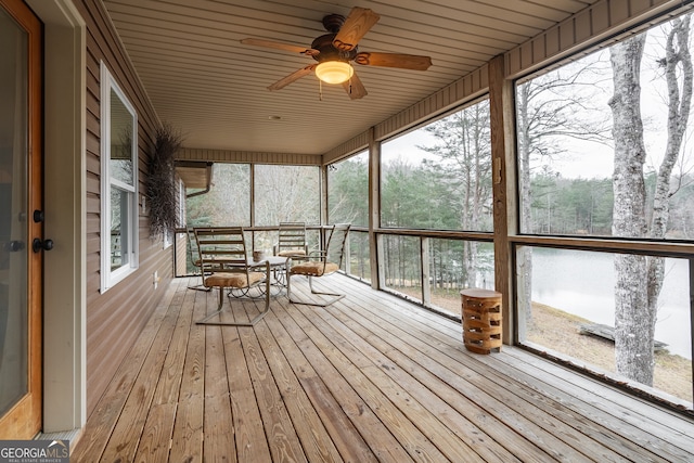 unfurnished sunroom featuring ceiling fan