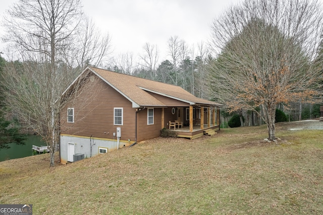 exterior space featuring a lawn, central air condition unit, and a wooden deck