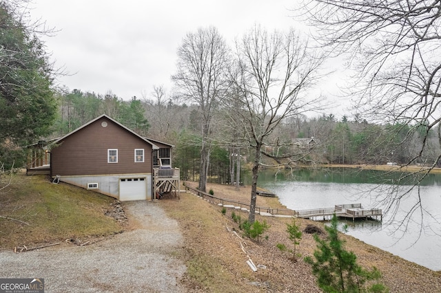 view of property exterior with a sunroom, a water view, and a garage