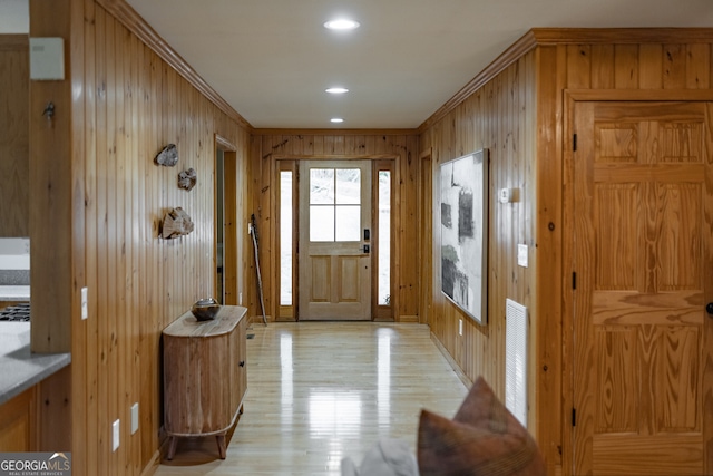 entryway with wood walls and ornamental molding