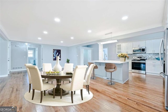 dining area featuring light wood-type flooring and sink