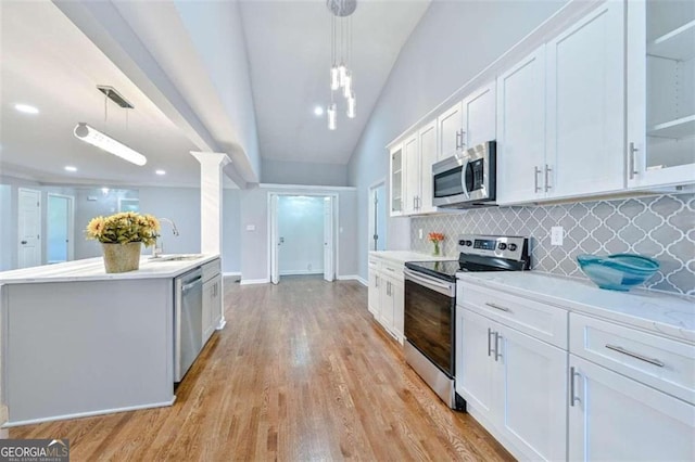 kitchen with appliances with stainless steel finishes, white cabinetry, pendant lighting, and sink