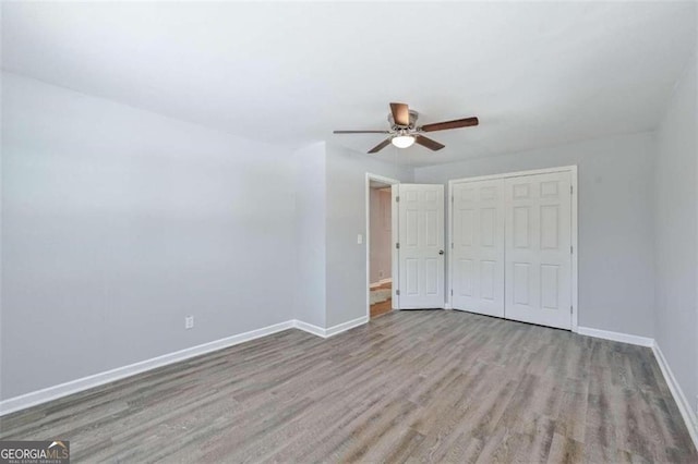 unfurnished bedroom featuring ceiling fan, a closet, and light wood-type flooring