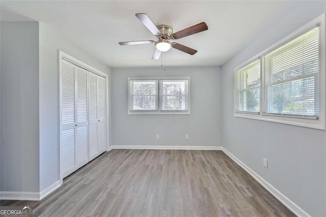 unfurnished bedroom featuring light wood-type flooring, a closet, and ceiling fan