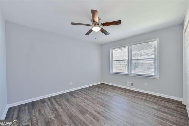 unfurnished room with ceiling fan and dark wood-type flooring