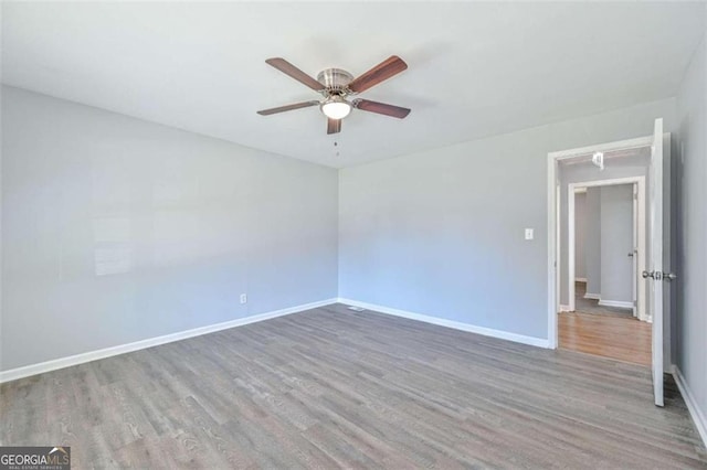 empty room with ceiling fan and wood-type flooring