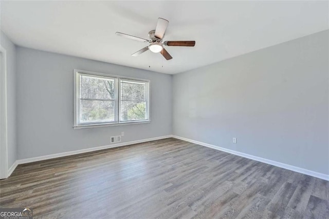 unfurnished room with dark hardwood / wood-style floors and ceiling fan