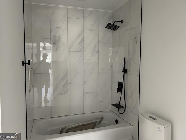 bathroom featuring toilet and tiled shower / bath