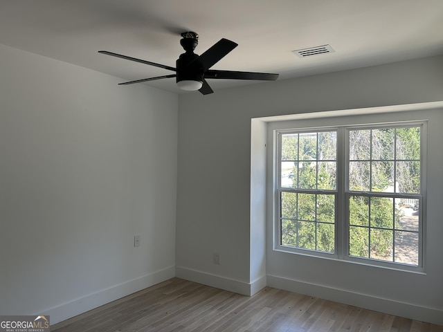 unfurnished room featuring ceiling fan, plenty of natural light, and light wood-type flooring