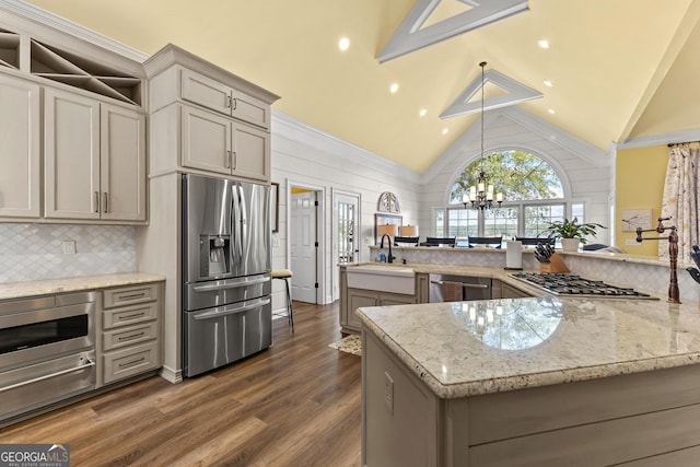 kitchen with sink, appliances with stainless steel finishes, gray cabinetry, and a notable chandelier