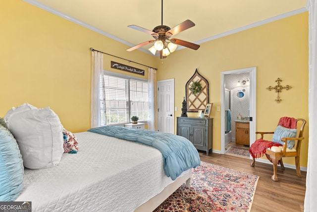 bedroom with ceiling fan, light wood-type flooring, crown molding, and connected bathroom