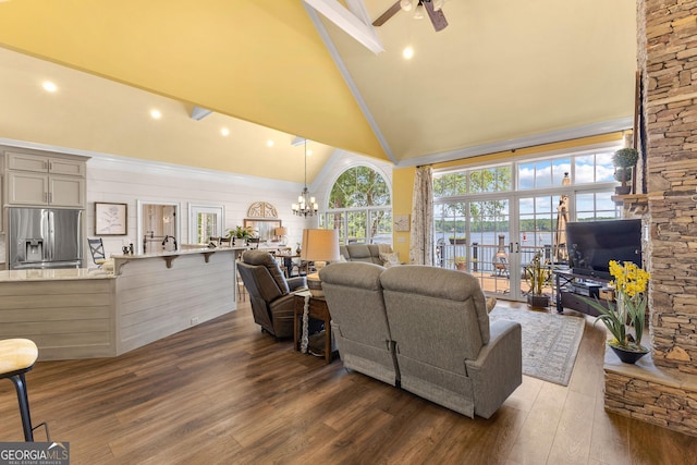 living room with high vaulted ceiling, dark hardwood / wood-style flooring, and ceiling fan with notable chandelier