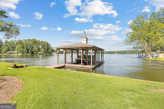 dock area with a lawn and a water view