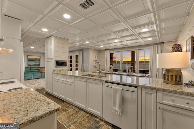 kitchen featuring white cabinets, appliances with stainless steel finishes, light stone countertops, and sink