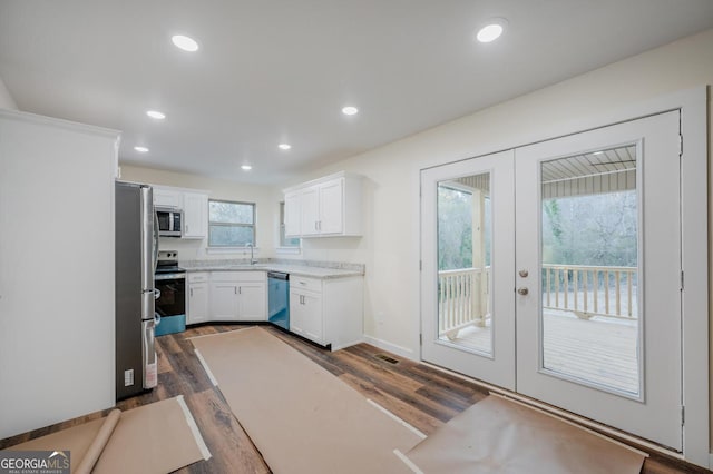 kitchen featuring dark wood-type flooring, french doors, sink, white cabinetry, and stainless steel appliances