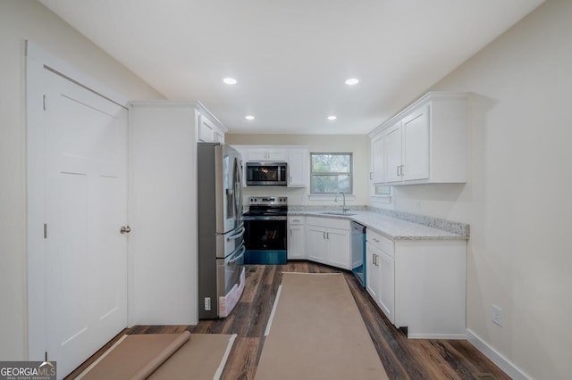 kitchen with white cabinets, appliances with stainless steel finishes, dark hardwood / wood-style floors, and sink