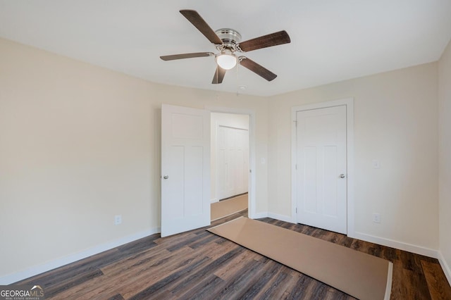 unfurnished bedroom featuring ceiling fan and dark hardwood / wood-style floors