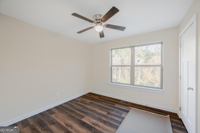 unfurnished room featuring ceiling fan and dark wood-type flooring