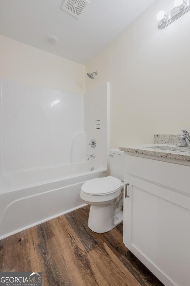 full bathroom with vanity, hardwood / wood-style flooring, toilet, and tub / shower combination